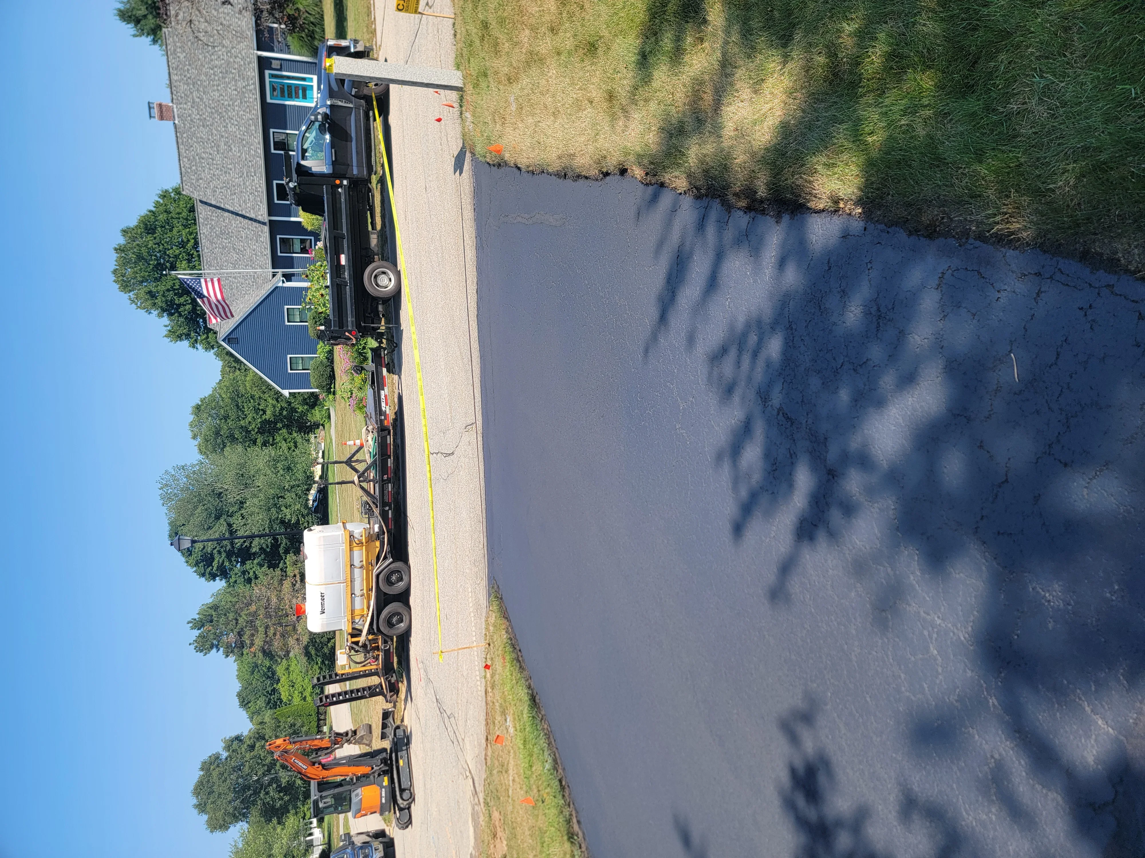 Freshly sealcoated asphalt driveway with dark finish and crisp edge lines